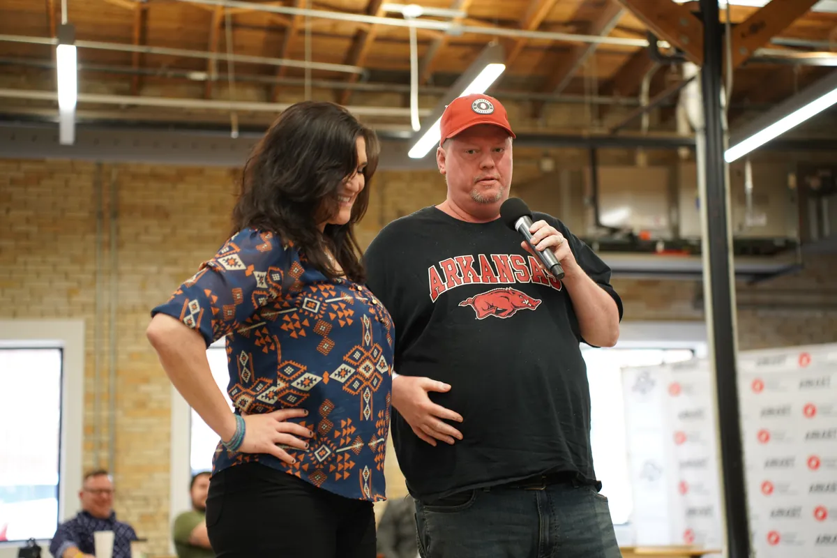 Two podcasters sharing a microphone during a session