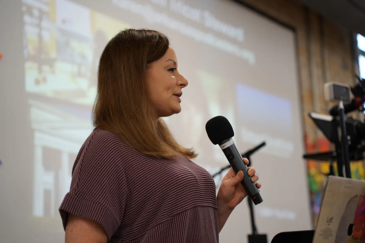 A workshop presenter speaking into a handheld microphone at ARKAST 2025
