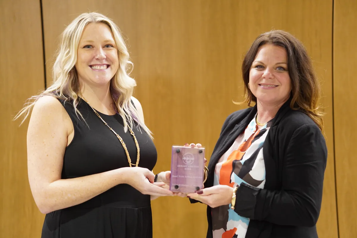 Two winners holding a trophy together at the 2024 ARKAST Awards