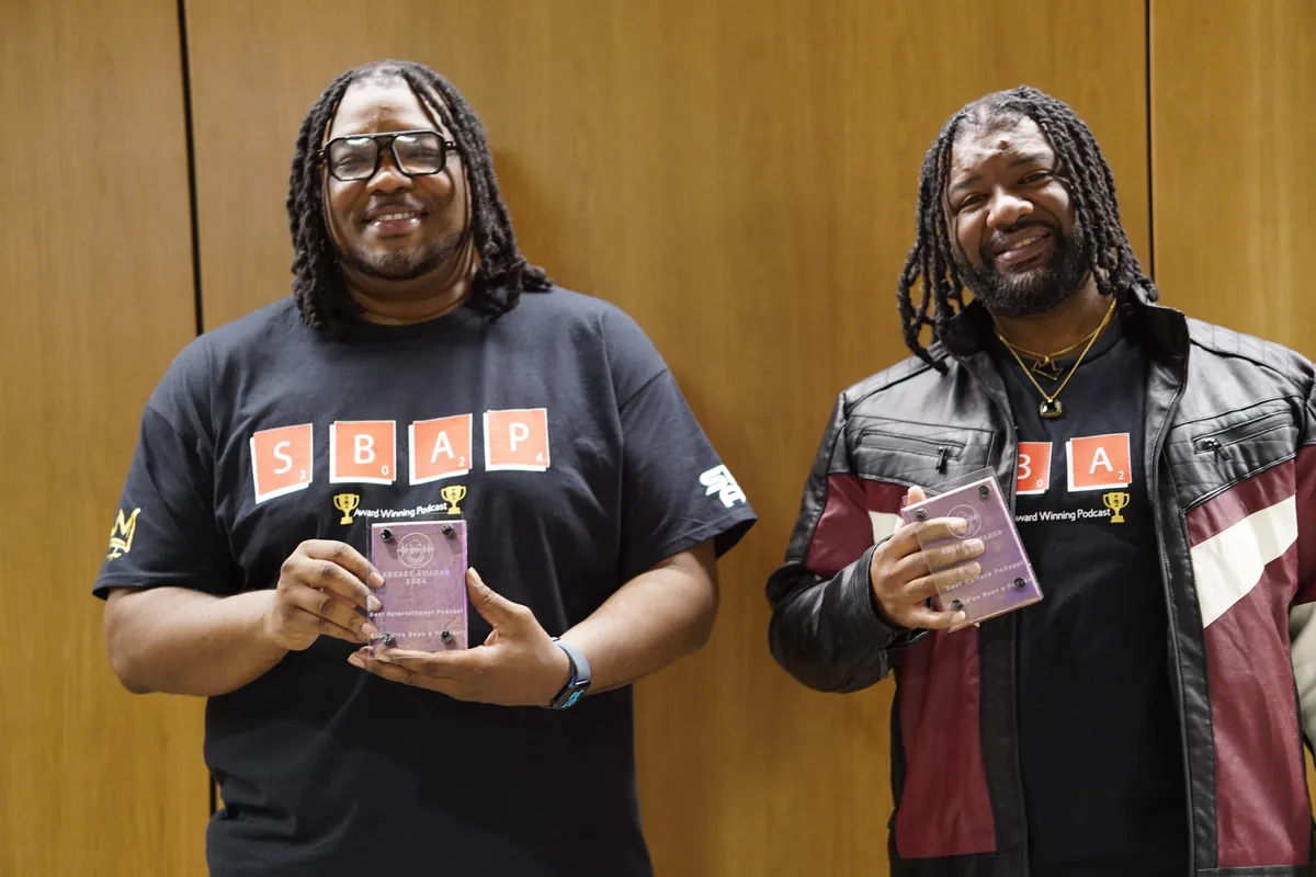 Two hosts holding their trophies at the 2024 ARKAST Awards