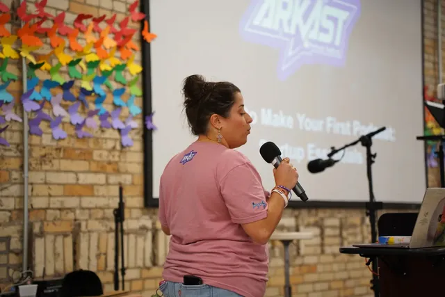 A presenter in front of the ARKAST screen in 2025